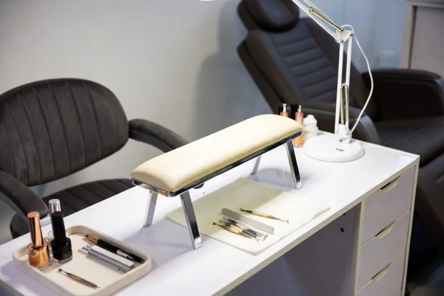 Ergonomic manicure table setup with comfortable seating for both technician and client – A guide to setting up your manicure table.