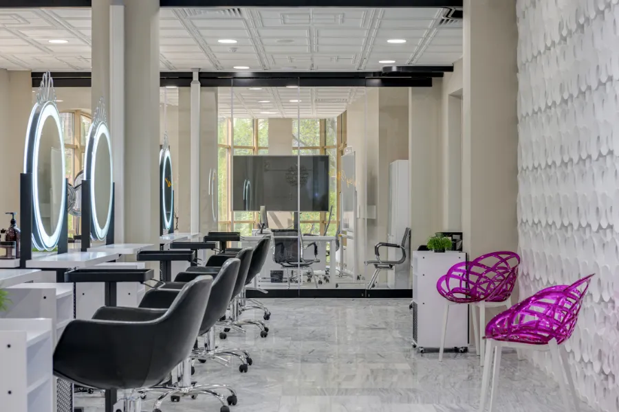 Hair and nail salon interior with styling chairs and workstations
