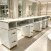 Luxury white manicure table with marble countertop and gold trim, multi-drawer nail salon station